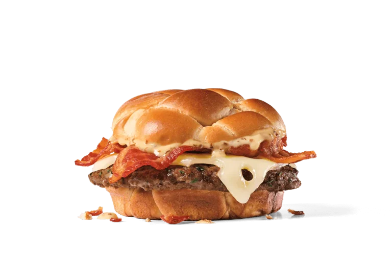 Image of a Bacon & Swiss Buttery Jack Burger featuring a juicy beef patty topped with melted Swiss cheese, several strips of crispy bacon, and a rich buttery sauce, all on a toasted artisan bun.