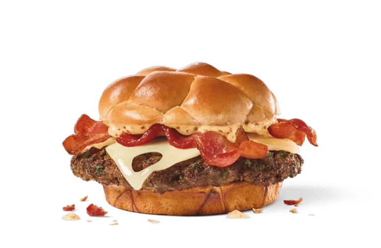 Image of a Bacon & Swiss Buttery Smashed Jack Burger, showcasing a thick beef patty topped with melted Swiss cheese, crispy bacon, and a dollop of spicy mayo, nestled between a buttery artisan bun.