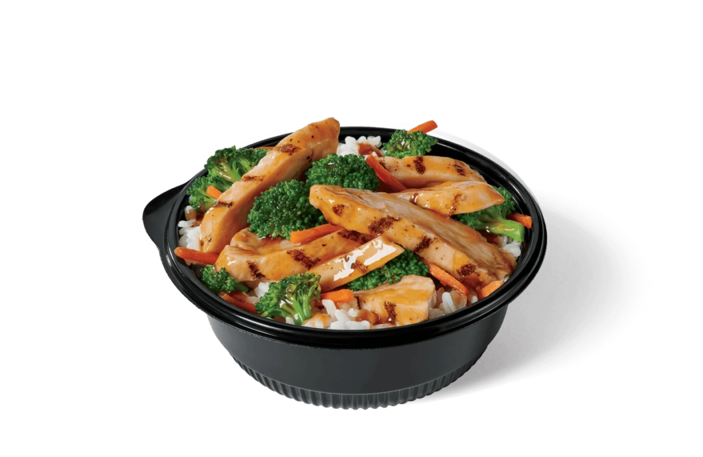 A nutritious and appetizing chicken teriyaki bowl filled with grilled chicken slices marinated in a teriyaki glaze, served over a bed of steamed white rice, complemented by vibrant broccoli and carrot slices, all contained in a black bowl on transparent background.