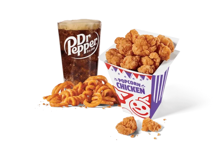 A delightful serving of classic popcorn chicken in a festive purple and white box, accompanied by curly fries and a refreshing glass of Dr Pepper, all set against transparent background. Ideal for a satisfying meal.