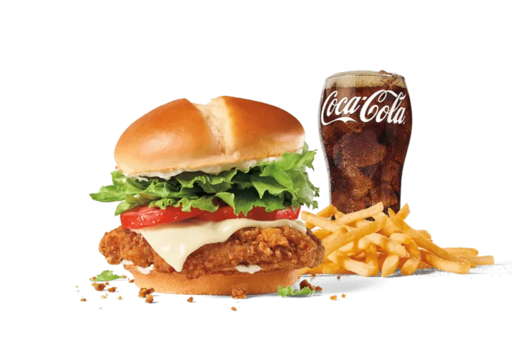 Jack's Spicy Chicken® sandwich with cheese, featuring a crispy chicken fillet topped with fresh lettuce, tomato, and creamy mayonnaise on a soft bun, paired with crispy fries and a glass of Coca-Cola, set against transparent background.