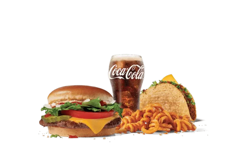 An appetizing fast food meal consisting of a junior chicken sandwich with lettuce, tomato, and cheese, a beef taco garnished with lettuce, a serving of curly fries, and a glass of Coca-Cola, all presented against a muted background.