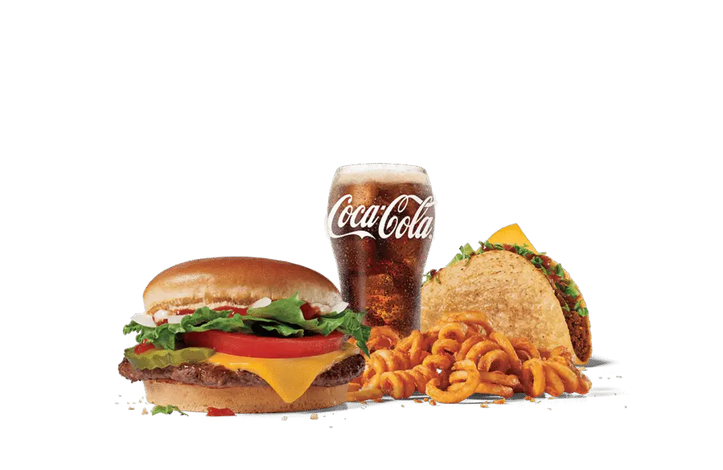 An appetizing fast food meal consisting of a junior chicken sandwich with lettuce, tomato, and cheese, a beef taco garnished with lettuce, a serving of curly fries, and a glass of Coca-Cola, all presented against a muted background.