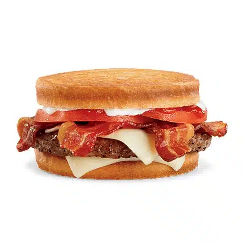 Image of a Sourdough Jack Burger with a beef patty, layers of melted Swiss cheese, crispy bacon, and slices of tomato, all sandwiched between two toasted sourdough bread rounds.