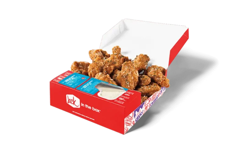 A 12-piece Garlic Parmesan Crispy Chicken Wings box from Jack in the Box, featuring crispy golden-brown wings generously coated in a flavorful garlic parmesan seasoning. The box includes a side of creamy dipping sauce and condiment packets, all packaged in a red box with the Jack in the Box logo. The open lid displays the wings for a visually appetizing presentation.