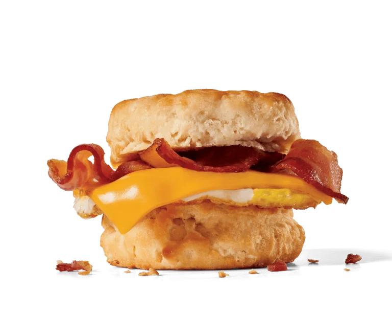 Image of a bacon, egg, and cheese biscuit, featuring a fluffy egg, a slice of melty American cheese, and crispy bacon strips peeking out from a soft, golden biscuit, all assembled into a delicious breakfast sandwich.