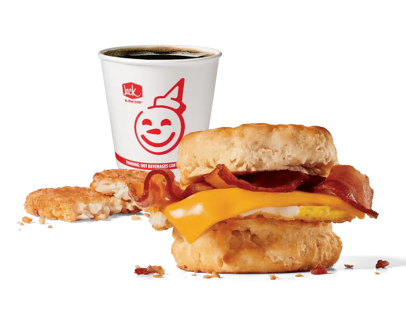 A delicious breakfast combo featuring a freshly baked biscuit sandwich filled with crispy bacon, melted cheese, and a fluffy egg, accompanied by a hash brown patty and a hot coffee in a branded Jack in the Box cup, all set against a transparent background.
