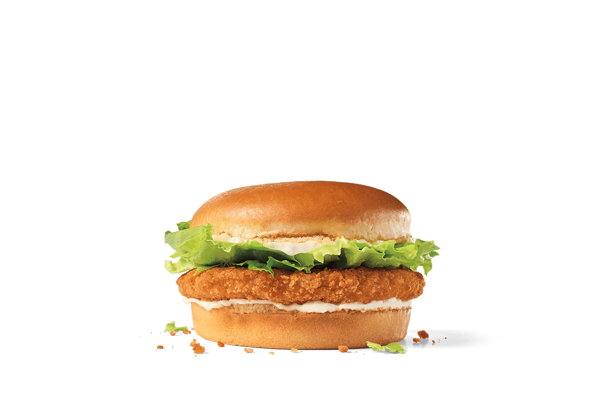 A crispy chicken sandwich with fresh lettuce and mayonnaise on a soft, toasted bun, set against a transparent background.