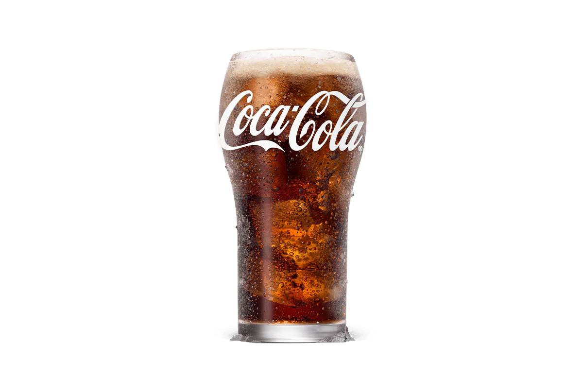 A tall glass of Coca-Cola® filled with ice cubes, featuring the signature dark and fizzy soda topped with a light foam layer, providing a refreshing drink experience.