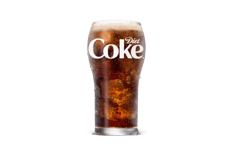 A tall glass of Diet Coke® filled with ice cubes, showcasing the crisp and bubbly dark soda topped with a light foam layer, offering a low-calorie refreshment option.
