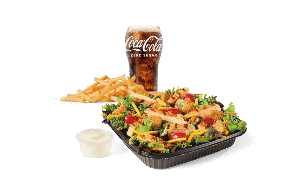 A fresh Garden Salad topped with grilled chicken strips, served with a side of French fries, a creamy dipping sauce, and a chilled Coca-Cola Zero Sugar drink.