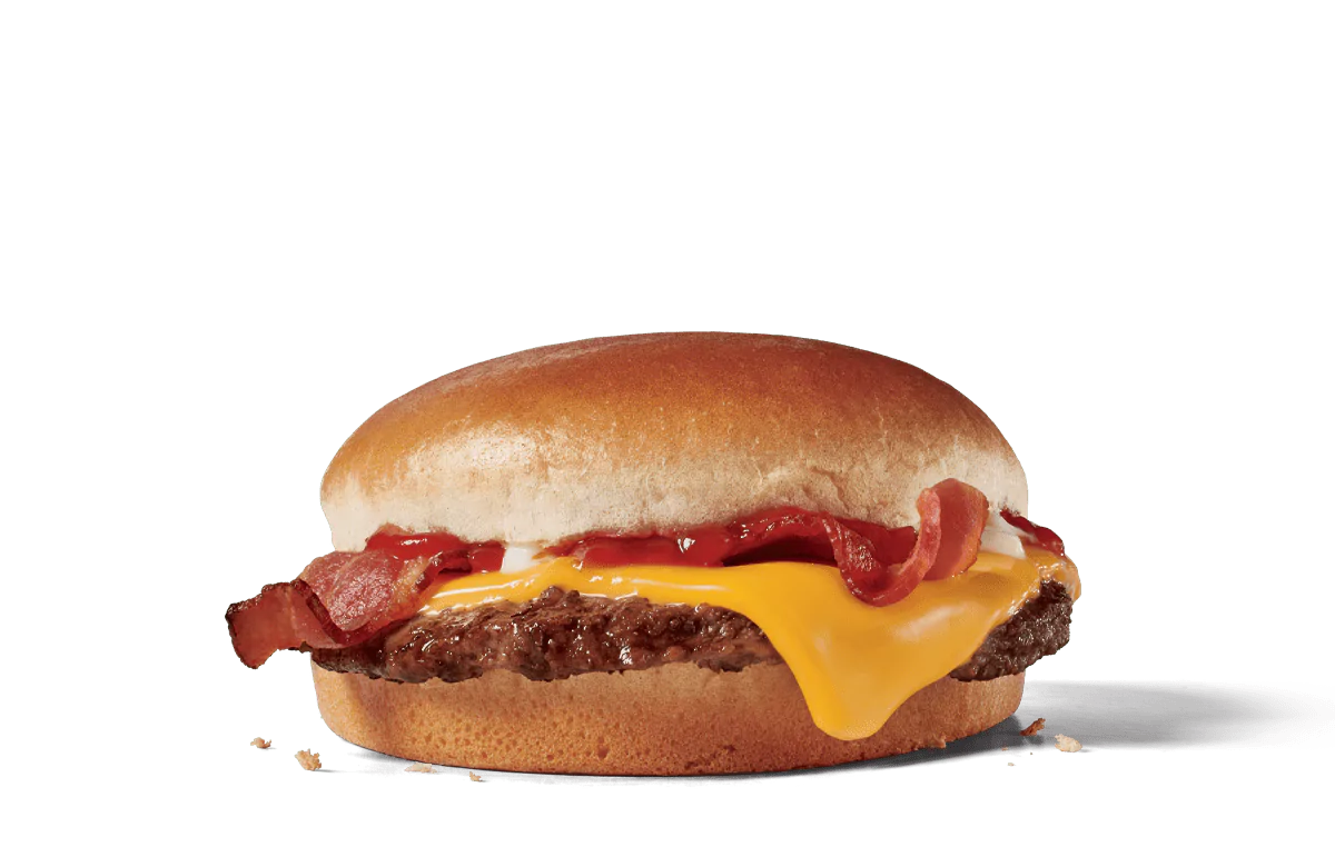 A Jr. Bacon Cheeseburger with a beef patty, melted American cheese, crispy bacon, and ketchup on a toasted bun, set against a transparent background.