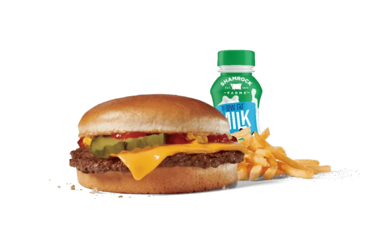 A tasty junior cheeseburger combo meal featuring a cheeseburger with a beef patty, cheese, ketchup, mustard, and pickles on a sesame seed bun, served with crispy golden fries and a bottle of low-fat milk. The items are presented against transparent background, showcasing the appealing, colorful contrast and inviting look of this kid-friendly meal option.