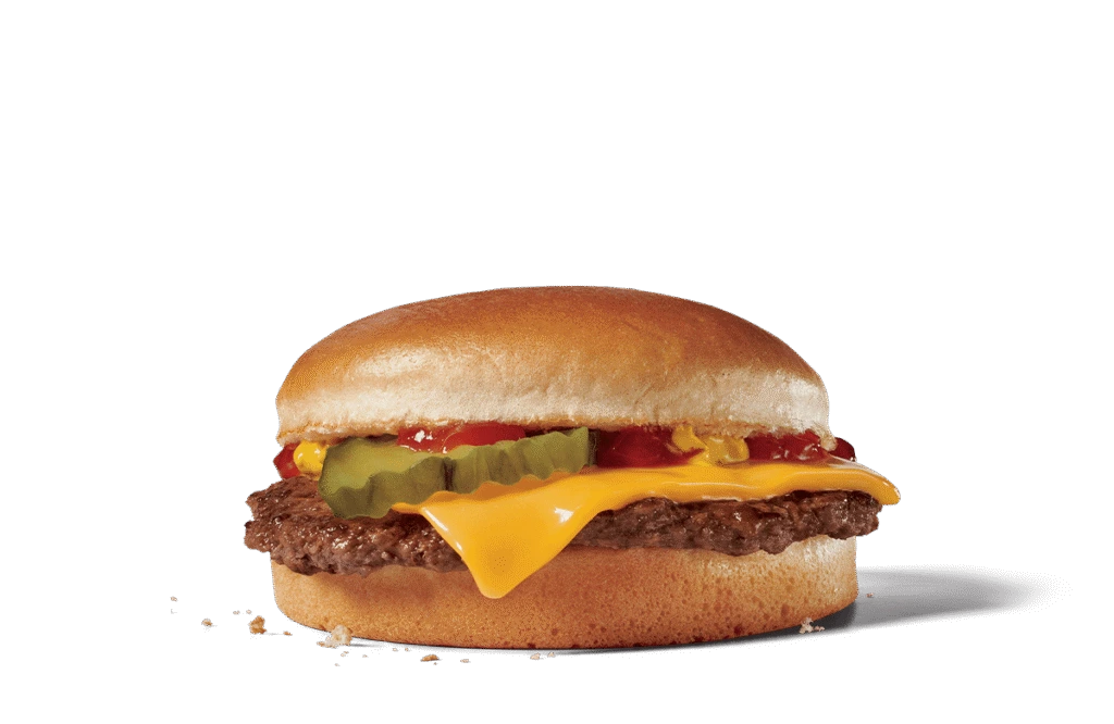 A close-up view of a junior cheeseburger showcasing a juicy beef patty topped with melty cheese, bright yellow mustard, ketchup, and crisp pickles, all sandwiched between a soft, golden sesame seed bun. The burger is set against transparent background, emphasizing its colorful toppings and appetizing look, ideal for a satisfying small meal or snack.