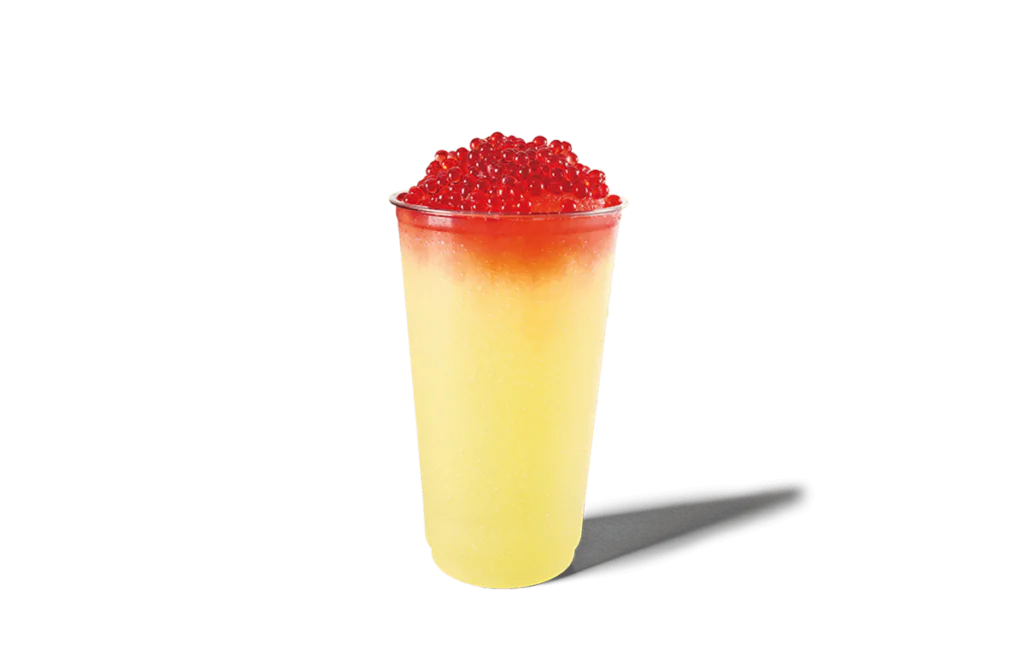 A refreshing lemonade slushie in a clear cup, topped with vibrant red strawberry bursting boba. The drink features a gradient of yellow to red, creating a visually striking and inviting summer beverage.