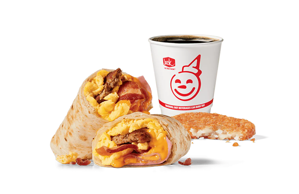 Image showcasing Jack in the Box's Meat Lovers Burrito Combo, featuring a breakfast burrito stuffed with sausage, bacon, scrambled eggs, and melted cheese, cut in half to reveal the filling. The combo includes a crispy hash brown and a coffee cup with the smiling Jack in the Box logo on a transparent background, emphasizing a hearty and satisfying breakfast option.