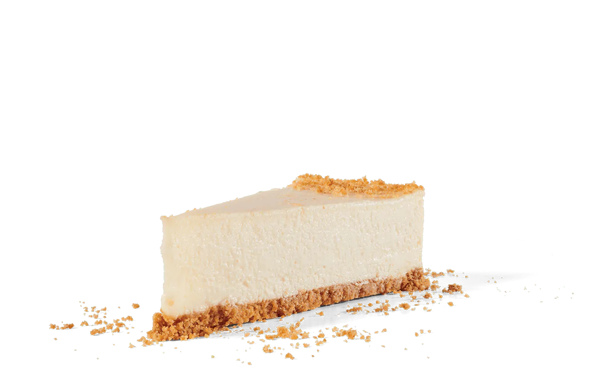 A perfect slice of New York style cheesecake with a smooth, creamy texture and a rich golden crust. The cheesecake is positioned on transparent background with crumbs scattered around the base, emphasizing its delicate yet dense composition and inviting appearance.