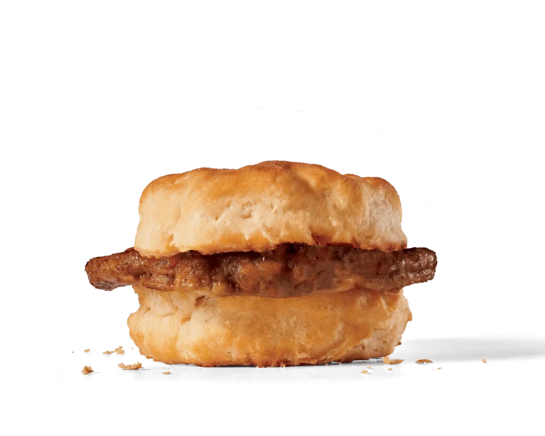 Image of a Sausage Biscuit featuring a thick, savory sausage patty encased in a soft, golden-brown biscuit, with visible crumbs indicating the crispiness of the biscuit and the juiciness of the sausage.