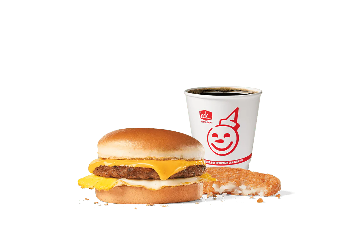 A delicious Sausage Breakfast Jack® Combo from Jack in the Box featuring a sandwich with a sausage patty, egg, and American cheese on a toasted bun. Paired with a crispy hash brown and a cup of hot coffee, set against a transparent background.
