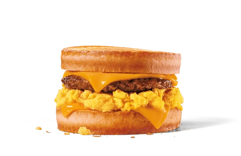 Image of a Sausage, Egg & Cheese Scrambler sandwich featuring fluffy scrambled eggs, a juicy sausage patty, and melted American cheese sandwiched between two lightly toasted English muffins, showcasing a hearty and savory breakfast option.