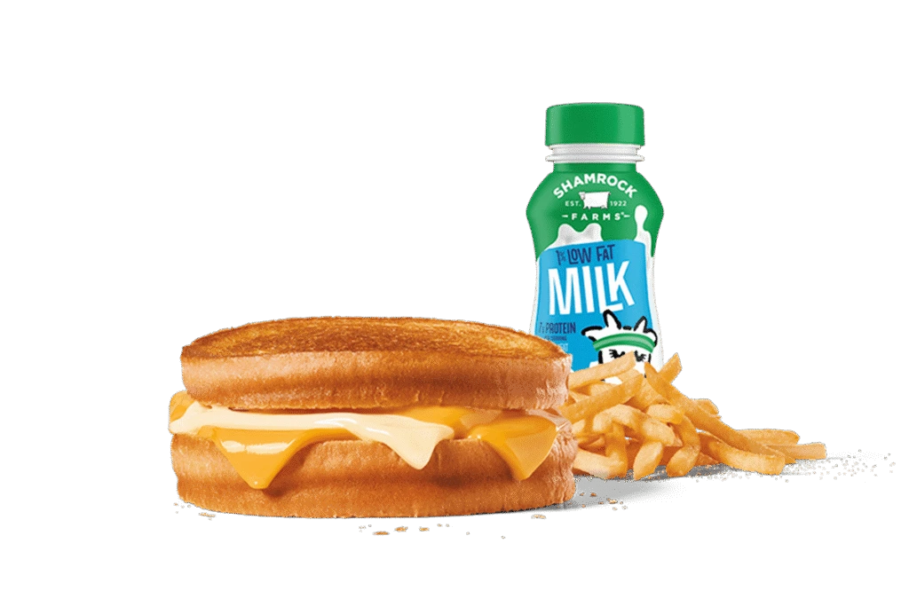 A delectable sourdough grilled cheese sandwich with melted cheese oozing out between toasted slices, paired with a side of crispy French fries and a bottle of low-fat milk. The meal is presented against a muted gray background, highlighting the golden brown crust of the sandwich and the vibrant yellow of the cheese, making it a comforting and satisfying meal choice.