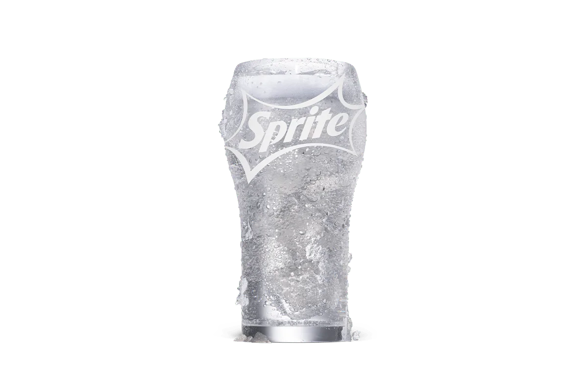 A refreshing glass of Sprite® served over ice in a transparent glass with the Sprite logo prominently displayed. The drink appears crisp and bubbly, highlighting its fizzy and thirst-quenching nature. Droplets of condensation on the glass emphasize its chilled state.