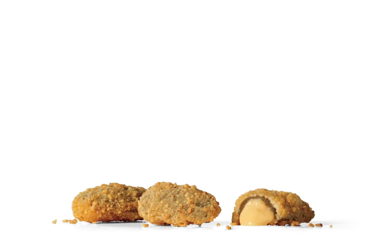 Several golden-brown crispy stuffed jalapeños on transparent background. One jalapeño is sliced open, showcasing a gooey cheese center, with crumbs scattered around the jalapeños. The breadcrumb coating on the jalapeños provides a textured appearance.