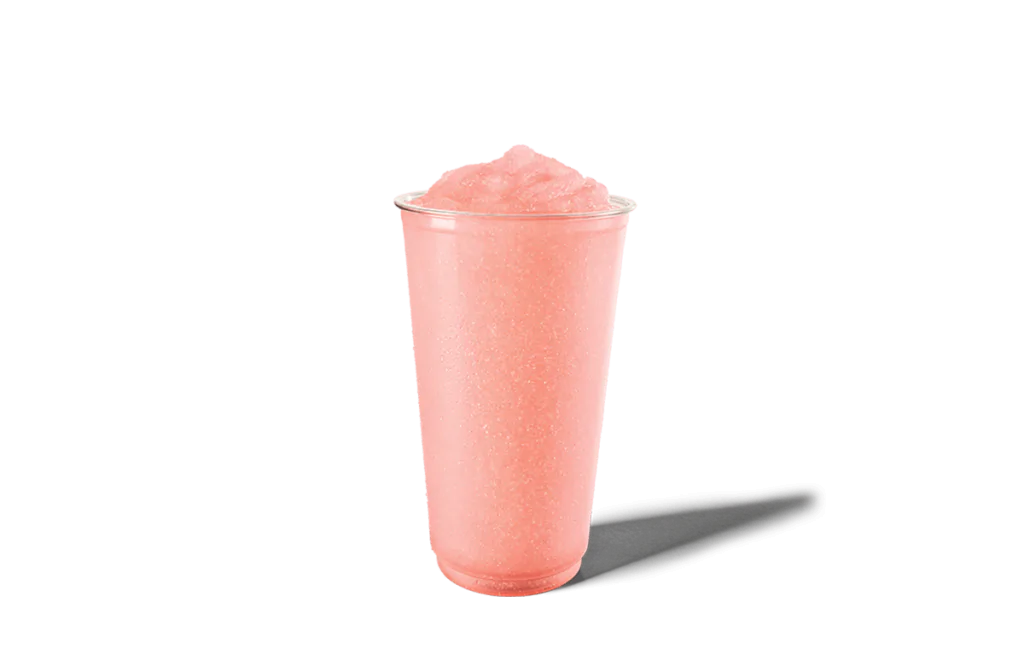 A clear cup filled with a light pink watermelon slushie. The drink has a frosty, icy texture, offering a sweet and refreshing flavor perfect for summer days.